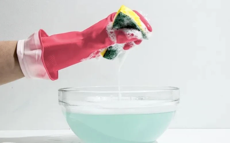 Dùng nước rửa chén pha nước ấm để tẩy rửa chậu rửa bát